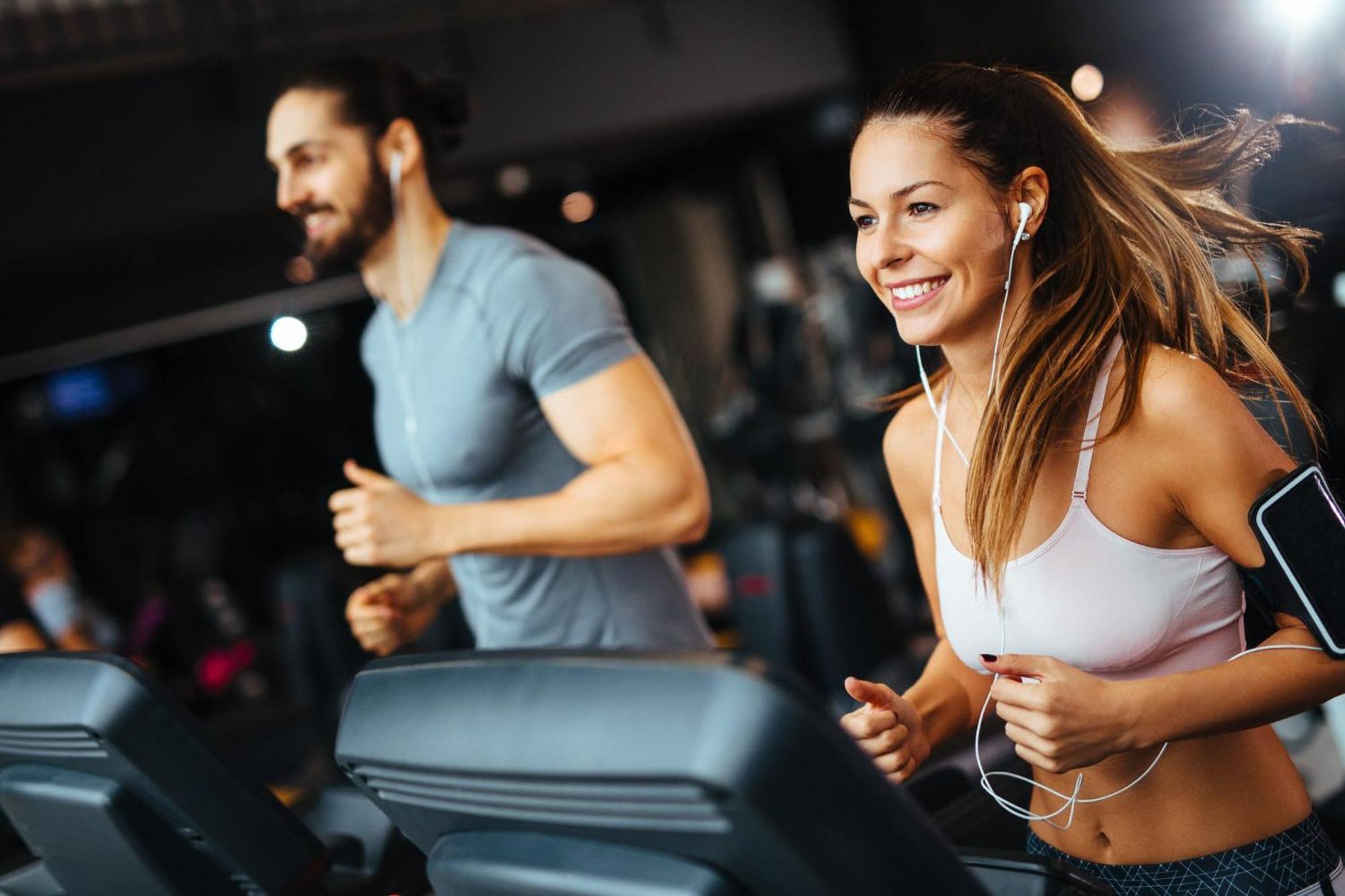 Crowne Plaza Changi Airport By Ihg Сінгапур Екстер'єр фото The photo shows two individuals running on treadmills in a gym. The woman, wearing a sports bra and workout leggings, has earbuds in and is smiling as she runs. The man, next to her, wears a fitted t-shirt and appears to be focused on his workout. Bo
